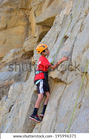 KERN COUNTY, CA-MAY 31, 2014: Nick Olsen is one of several teenage students from Olive Knolls Christian School who are building confidence by getting climbing instruction today.