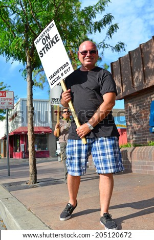 BAKERSFIELD, CA-JULY 15, 2014: After six months failed negotiations the teamsters union strikes the Golden Empire Transit District. An unidentified union member lends his support in the extreme heat.