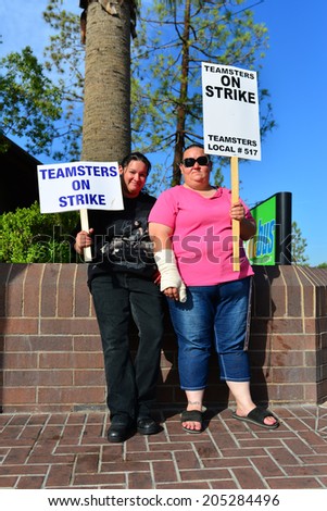 BAKERSFIELD, CA-JULY 15, 2014: After six months failed negotiations the teamsters union strikes the Golden Empire Transit District. Two unidentified women bus drivers display their signs.