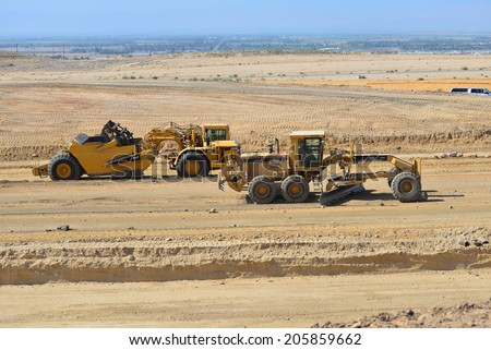 BAKERSFIELD, CA-JULY 18, 2014: A motor scraper and a blade help to bring the road base up to grade during the project to widen State Route 178.