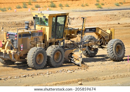 BAKERSFIELD, CA-JULY 18, 2014: Equipment with a blade is used to bring the road base to grade during the project to widen State Route 178.