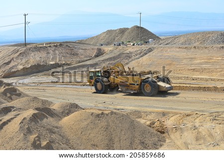 BAKERSFIELD, CA-JULY 18, 2014: A motor scraper helps to bring the road base up to grade during the project to widen State Route 178.
