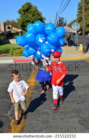 WASCO, CA - SEPTEMBER 6, 2014: The Garrison family children are giving away free blue balloons for everyone prior to the start of the  parade at the city\'s Festival of Roses.