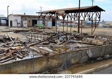 BAKERSFIELD, CA - DECEMBER 13, 2014: A large abandoned factory building is being demolished. After the site is cleared a new industrial structure will take its place.