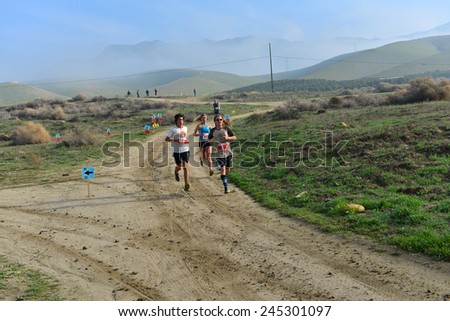 BAKERSFIELD, CA - JAN 17, 2015: Contestants run the first stage of the Rio Bravo Rumble biathlon (running and mountain biking) on a scenic dirt trail.