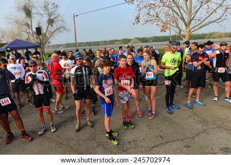 BAKERSFIELD, CA - JAN 17, 2015: Contestants line up at the start of the Rio Bravo Rumble running portion of the biathlon (running and mountain biking) under cold and foggy conditions.