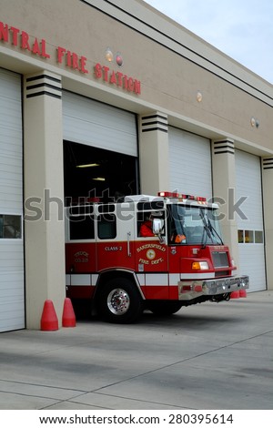 BAKERSFIELD, CA - MAY 21, 2015: A fire truck with firemen personnel departs the Central Fire Station after receiving a call.