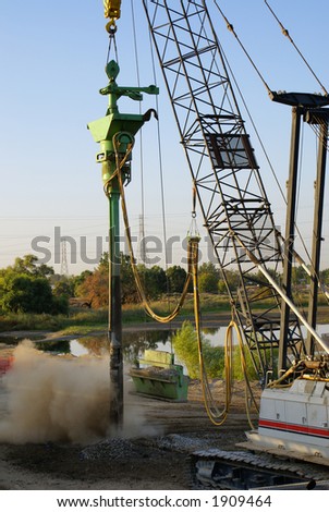 A crane is used to place gravel or concrete as needed on a bridge construction project