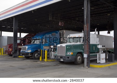 Tractor trailer rigs parked at truck stop for servicing