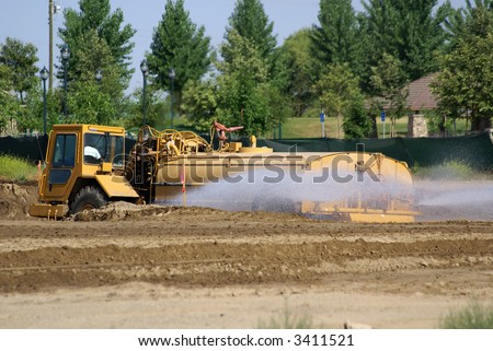 Water truck sprays construction job site for compaction and dust control