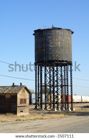 Obsolete water tower and pump house along the railroad tracks, Central California