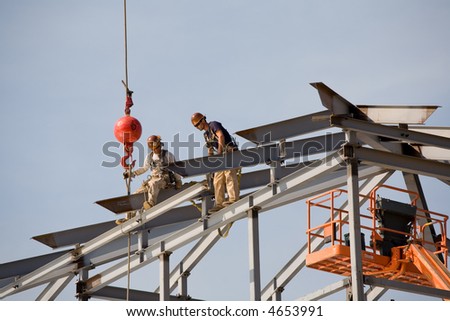 Ironworkers set steel beams high in the air on construction project
