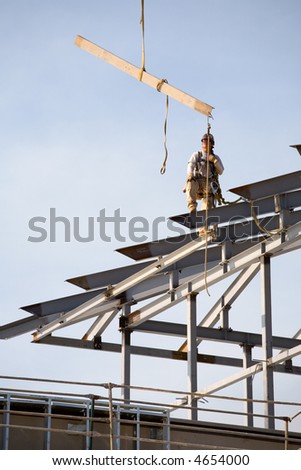 Ironworkers set steel beams high in the air on construction project