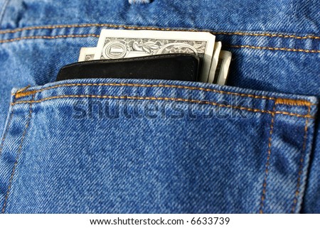 Wallet with money in back pocket of blue jeans