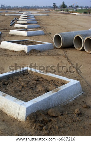 Concrete curbs, concrete pipe and plastic (PVC) conduit on construction job site
