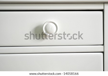 Background or texture: White painted drawers and pull knobs in chest