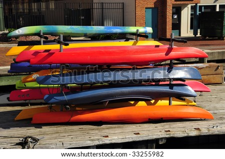 Colorful rental kayaks are stacked on the dock, Inner Harbor, Baltimore, MD