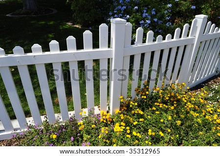 Residential white picket fence with yellow flower accents