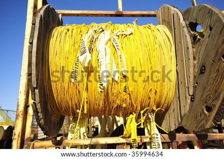 Yellow polypropylene rope with caution banners attached is used for event crowd control and stored on reels