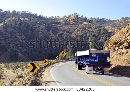 A truck trailer rig rounds a dangerous mountain curve, Sierra Nevada Range, California