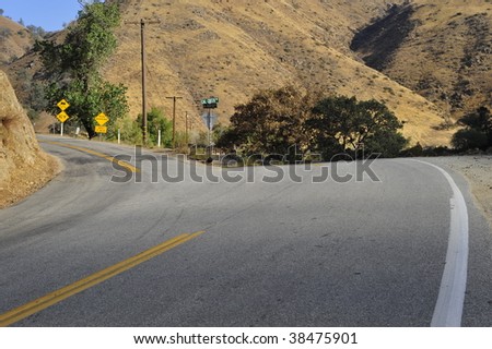 A narrow mountain road forks off the main highway