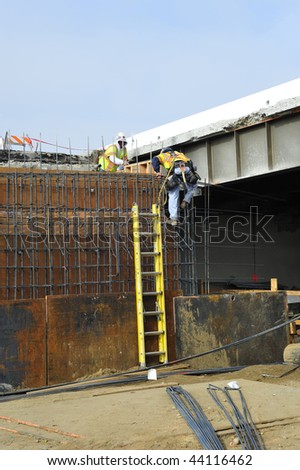 Bridge widening construction project: Workman climbs reinforcing bars used in concrete forms