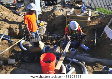 BAKERSFIELD, CA - AUG 12: Electricians completely replace traffic signals, poles and mast arms at a major intersection on August 12, 2010, at Bakersfield, California. Underground conduit is repaired.