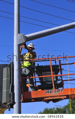 BAKERSFIELD, CA - AUG 12: Electricians completely replace traffic signals, poles and mast arms at a major intersection on August 12, 2010, at Bakersfield, California.