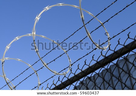 stock-photo-concertina-razor-wire-and-barbed-wire-atop-a-security-fence-59603437.jpg