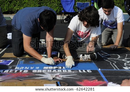 BAKERSFIELD, CA - OCT 9: Local students and artists apply chalk to asphalt for the Via Arte Italian Street Painting Festival on October 9, 2010, at Bakersfield, California