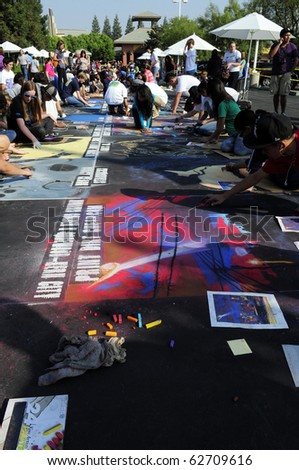 BAKERSFIELD, CA - OCT 9: Local students and artists apply chalk to asphalt for the Via Arte Italian Street Painting Festival on October 9, 2010, in Bakersfield, California