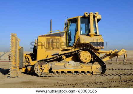 Construction job site: Blade in front and ripping teeth in rear of tracked equipment