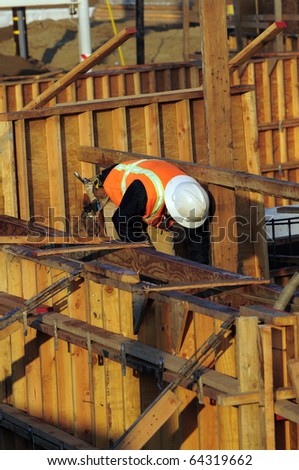 Workman is surrounded by a maze of wooden concrete forms on a bridge construction project