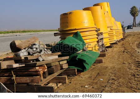 Stacks of plastic barrels to be filled with sand and used as temporary barriers on road construction project