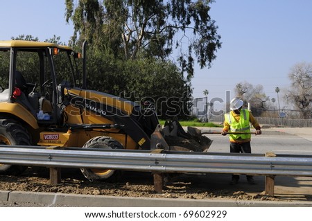 BAKERSFIELD, CA - JAN 22: Construction for the Manor Street on ramp is completed on January 22, 2011, at Bakersfield, California. Workman cleans area under new guard rails.