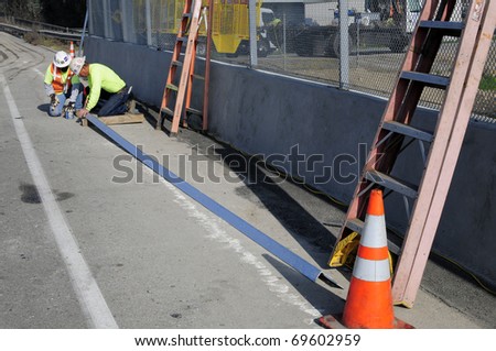 BAKERSFIELD, CA - JAN 22: Construction for the Manor Street on ramp is completed on January 22, 2011, at Bakersfield, California. Workmen finish barrier screen next to road.