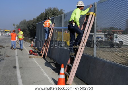 BAKERSFIELD, CA - JAN 22: Construction for the Manor Street on ramp is completed on January 22, 2011, at Bakersfield, California. Workmen finish barrier screen next to road.