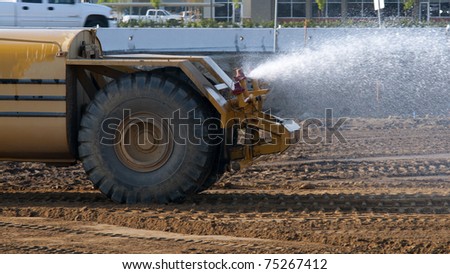 Water wagon sprays job site to mitigate dust on the project