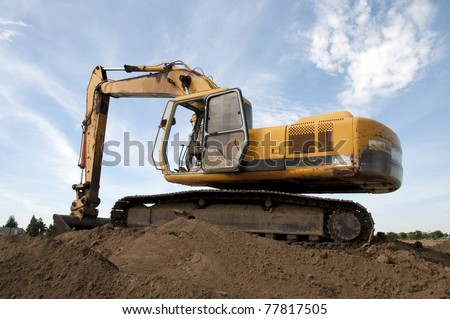 Heavy equipment prepares construction job site: Articulated boom and digging bucket