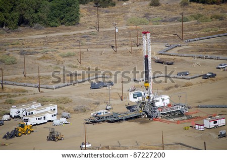 A drilling rig sets up on an existing oil lease