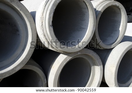 Precast concrete pipe is stacked on a construction job site