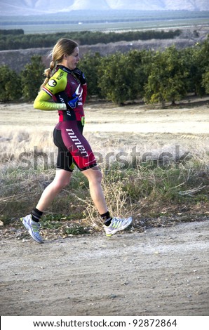 BAKERSFIELD, CA - JAN 14: An unidentified woman runs the dirt cross country leg of the Rio Bravo Rumble biathlon (running and mountain biking) on January 14, 2012, in Bakersfield, California.
