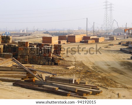 Contractor\'s lay down area for storage of wooden timbers, sheets and planks used on a bridge construction project