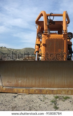 Construction job site: Tracked bulldozer with front blade attachment