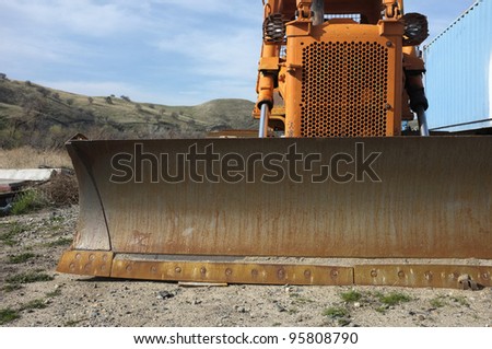 Construction job site: Tracked bulldozer with front blade attachment