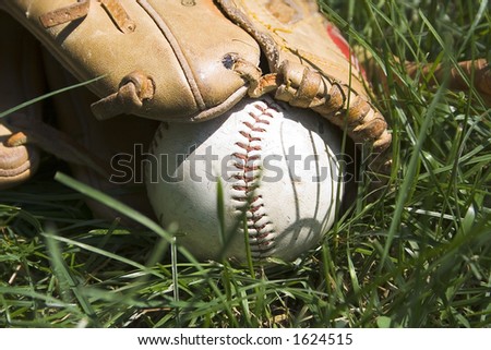 Worn old baseball and glove on the field after the game