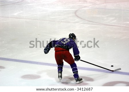 Forward in red pants and purple jersey wearing a number crossing the blue line heading towards the goal
