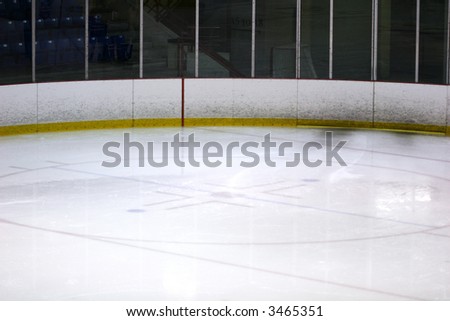 Photograph of a corner of a hockey arena including the face off dot and icing line.