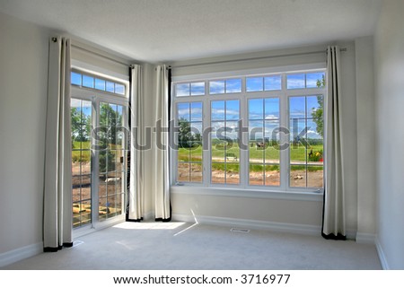 Scenic view from a model home bedroom with simple drapes hung on wrought iron with grommets