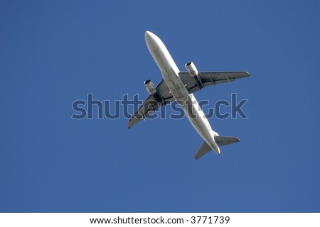 Large passenger plane flying.  Photo taken from ground with plane flying overhead.